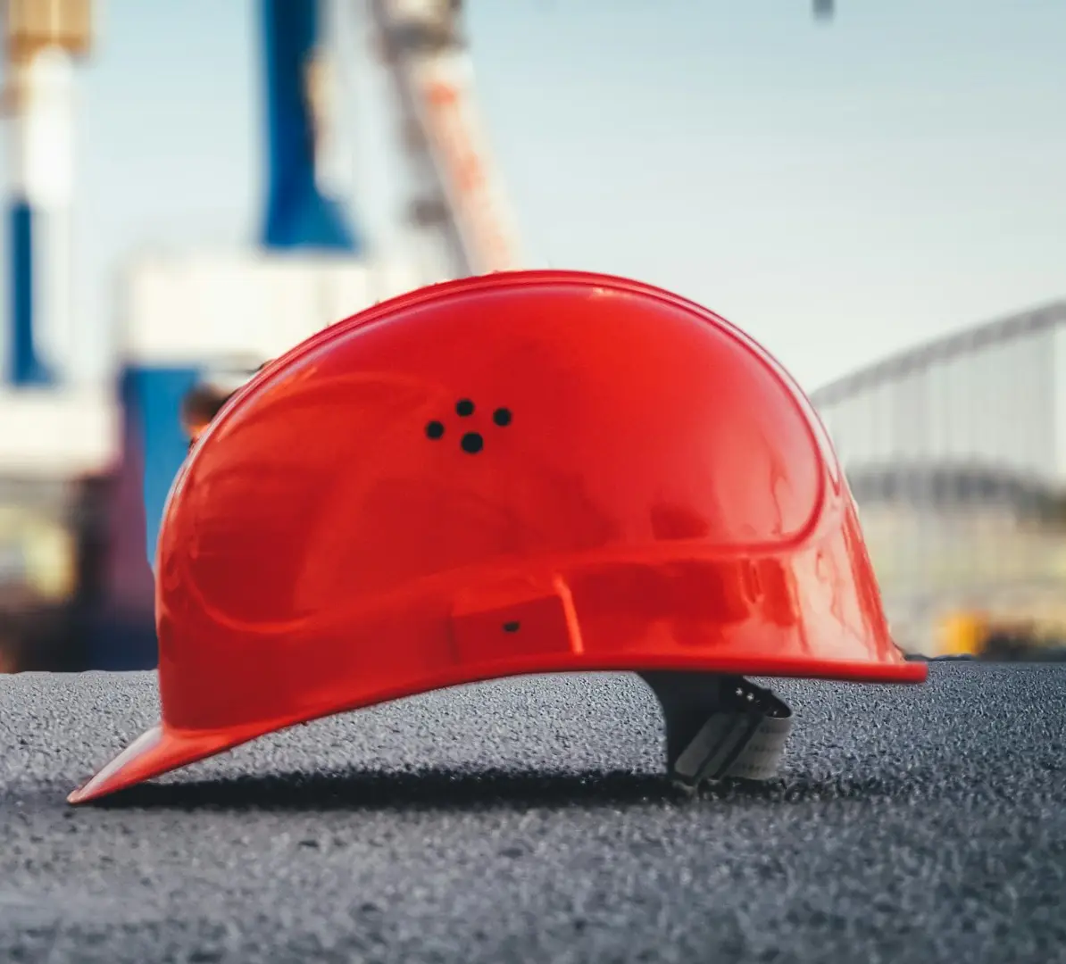 red hard hat on pavement\